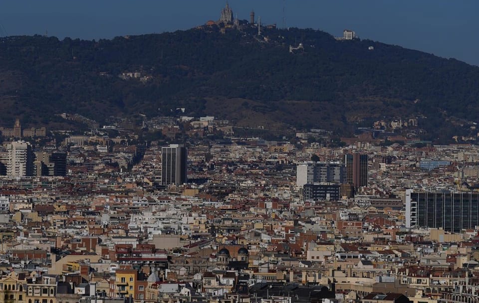A street sign for Plaça Virrei Amat in Barcelona, with the city's distinctive Eixample architecture in the background.