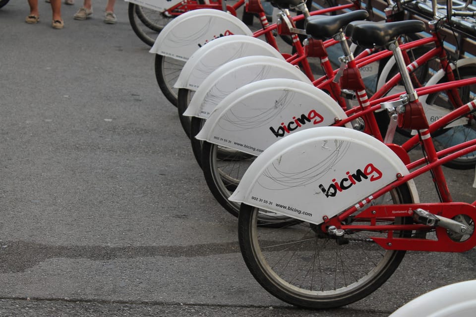 A red Bicing bike-share docking station on a Barcelona street