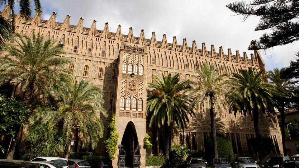Exterior view of the Teresianes school in Barcelona, designed by Antoni Gaudí, featuring its distinctive brick facade and arc