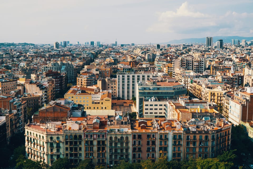 Police officers in uniform standing on Las Ramblas in Barcelona, with trees and buildings in the background.