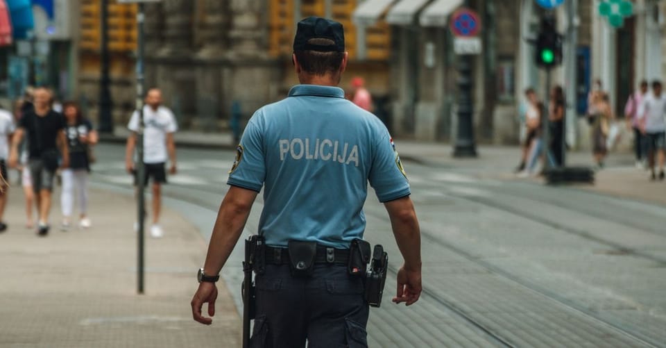 Police officers conducting a raid on a warehouse filled with boxes of counterfeit goods, including fake football shirts.