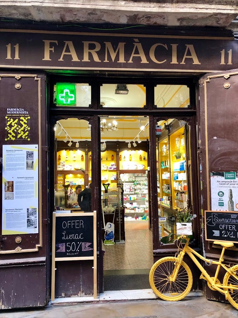 Historic shopfronts and old business signs on a Barcelona street, illustrating the debate over preserving commercial heritage.
