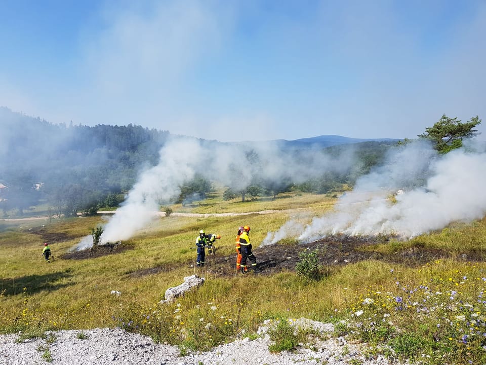 A wildfire-risk warning illustration for Catalonia, where firefighters are preparing for heightened forest-fire danger during hot and dry conditions.