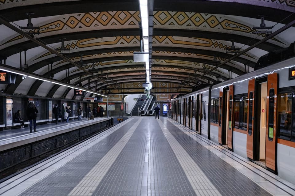 A Barcelona Metro train stopped beside a platform at an underground station in Barcelona.