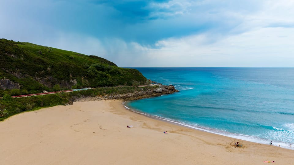 A Rodalies commuter train travelling beside the Catalan coast on a beach trip from Barcelona.