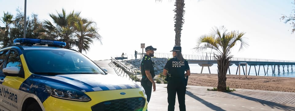 Police vehicles outside a residential building in Badalona following the arrest of a Belgian drug fugitive wanted in 31 countries.