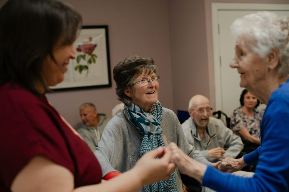 A care worker assisting an elderly person in a residential facility in Catalonia, highlighting the human impact of low pay in social services.