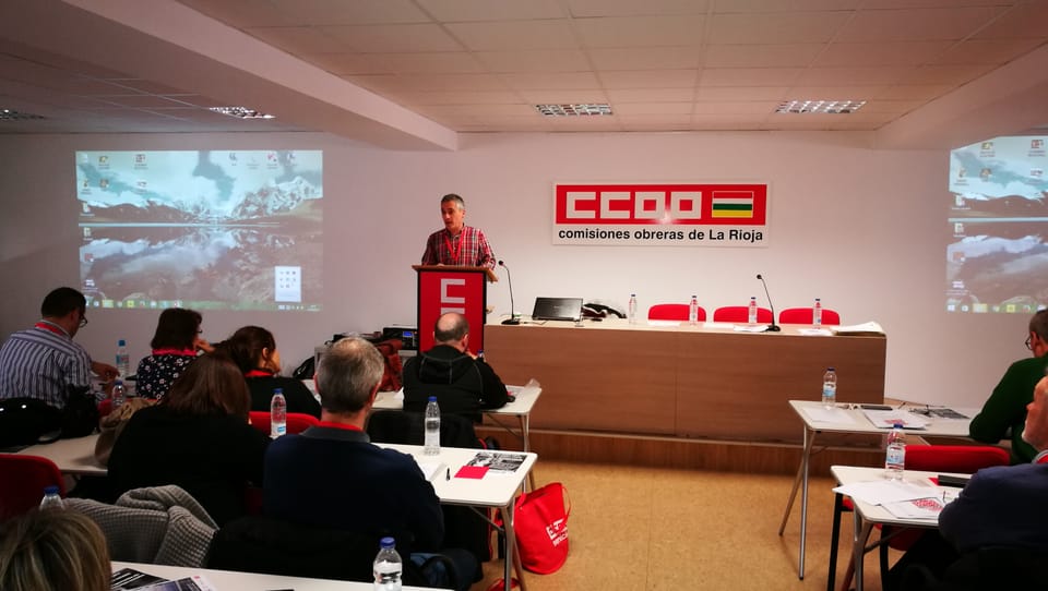 A construction worker handles materials beside a crane at a building site in Barcelona.