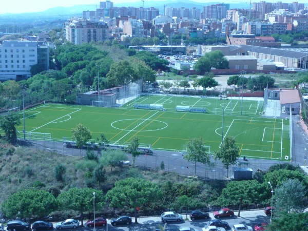 A shaded public park in L'Hospitalet with trees and seating, part of the city's climate shelter network to provide relief during summer heatwaves.