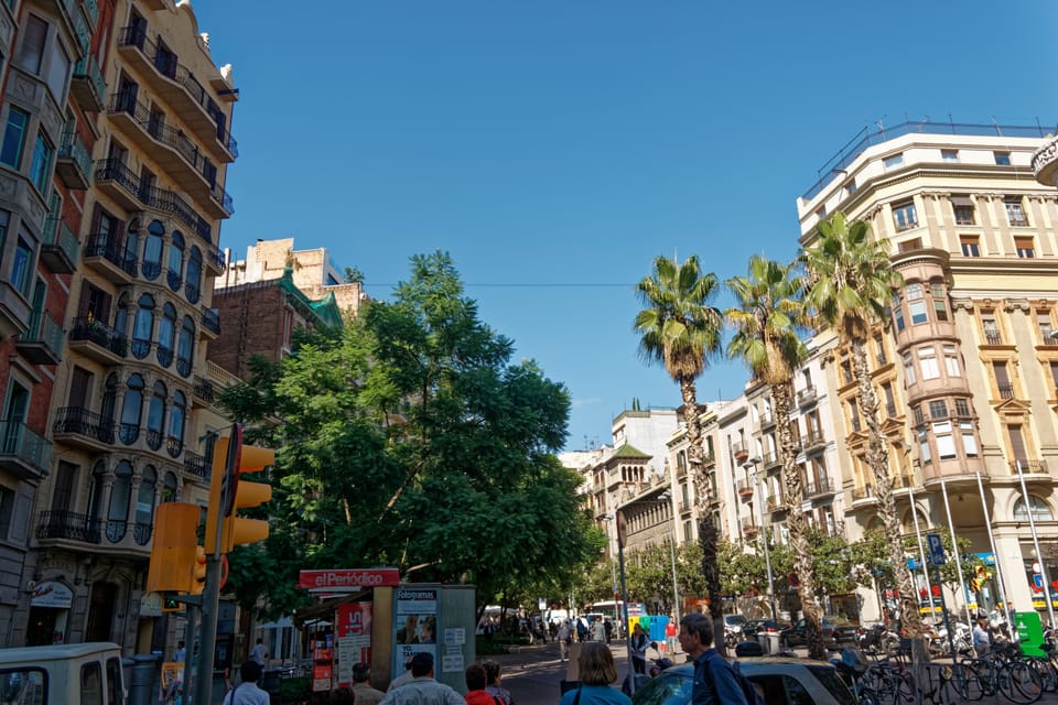 A queue forms outside the Chanel store on Passeig de Gràcia in Barcelona during summer, illustrating high foot traffic and demand.