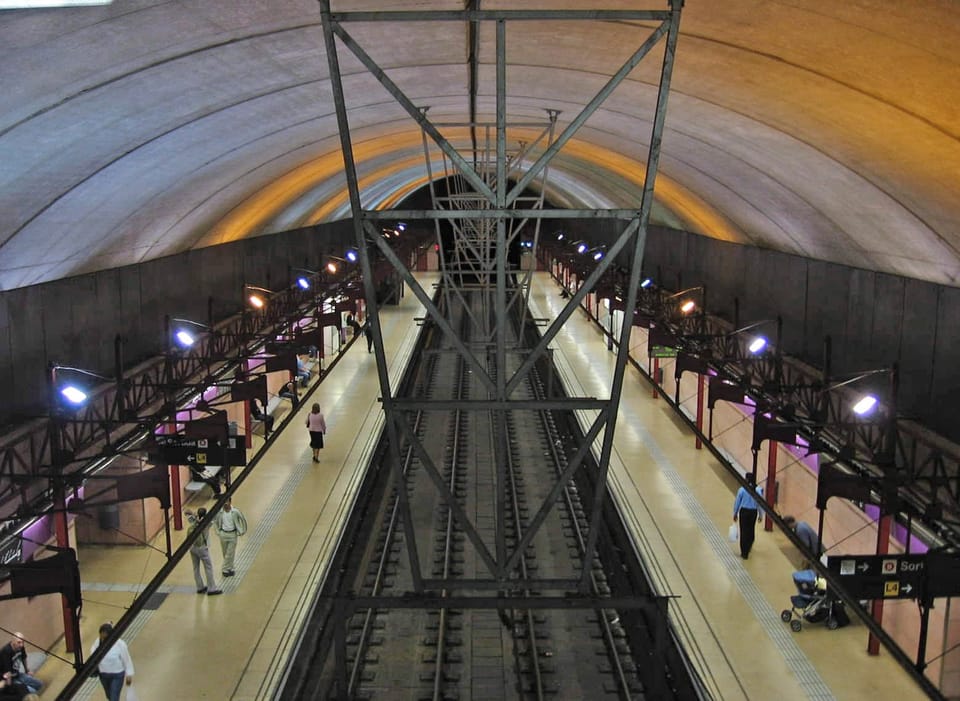 Mobile phone screen showing the Transporta'm app interface with real-time metro train locations and passenger density indicators in Barcelona.