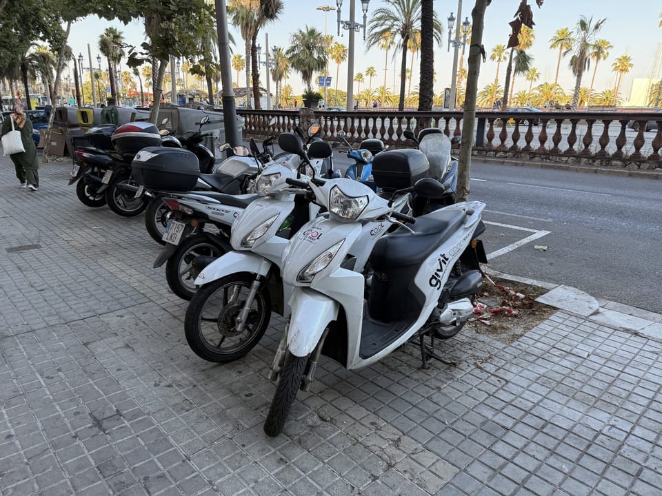 A wheel of an electric moped parked on a street in Barcelona, showing a clean urban mobility option.