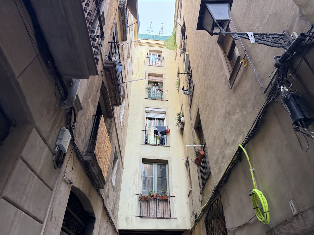 Cityscape of Barcelona with overlay text indicating housing affordability crisis, showing high rent prices and low availability in urban areas.