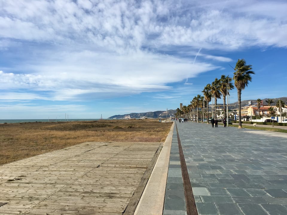 Castelldefels beach promenade with marked Blue and Green Zone parking bays under autumn skies.