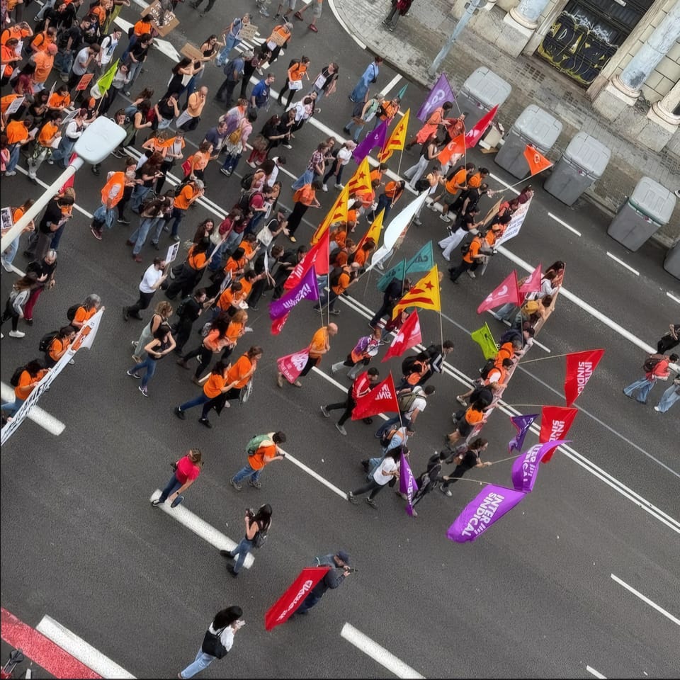 A protest march in Barcelona with teachers and healthcare workers holding banners calling for better pay and conditions.