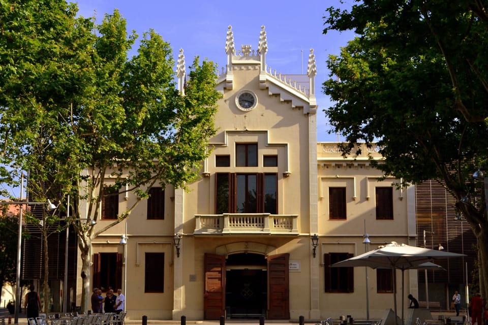 Exterior view of El Prat de Llobregat town hall with flag flying, during daylight hours.
