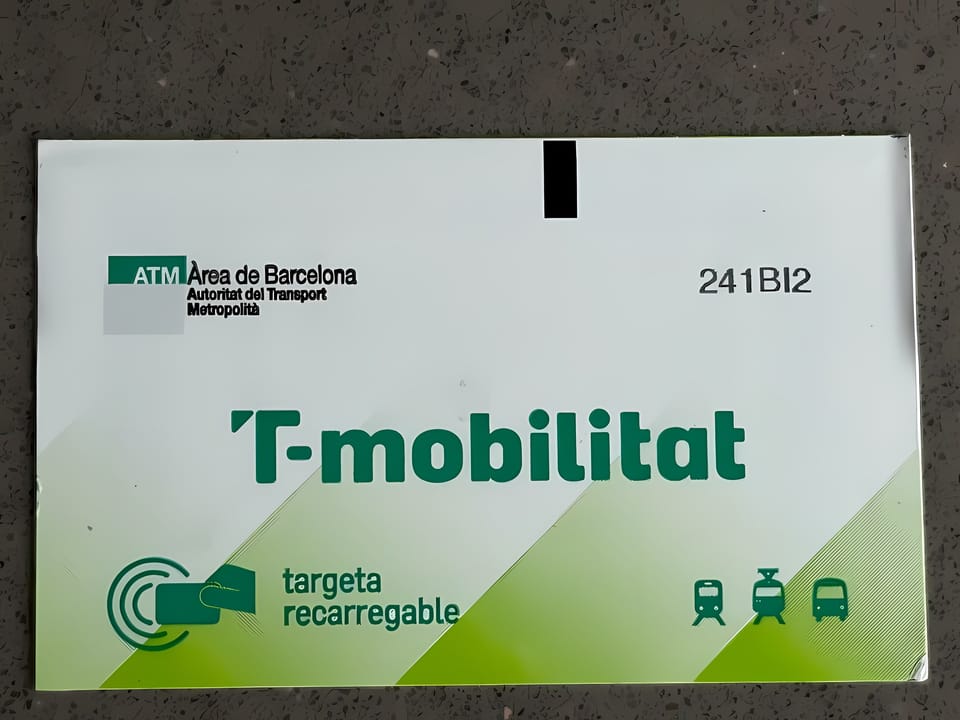 A contactless T-mobilitat card being tapped on a metro gate in Barcelona, with digital displays showing journey information.