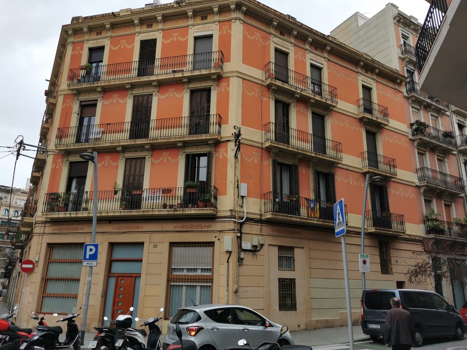 A residential street in Barcelona's Sants-Montjuïc district with a park nearby, where noise from youths playing ball has led to resident complaints.