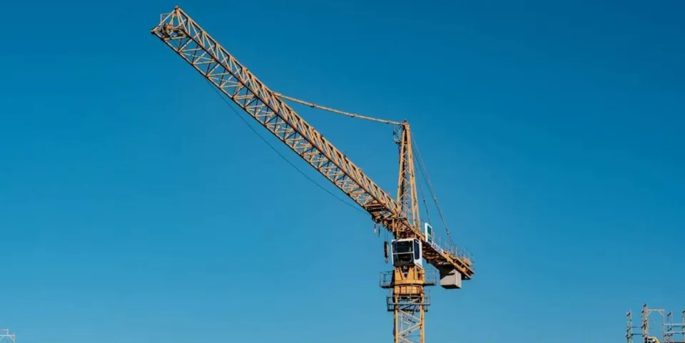 Emergency services personnel on a crane basket rescuing a man from a construction crane in Barcelona.