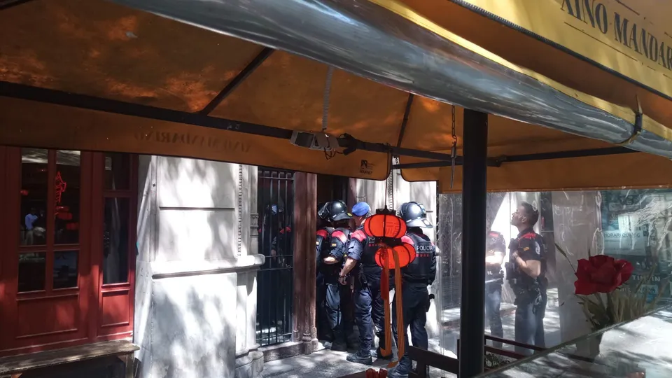 Police officers from Mossos d'Esquadra in tactical gear outside a building in Barcelona.