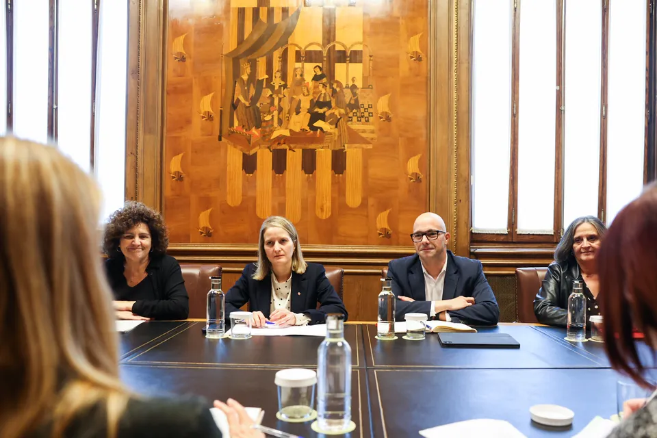 A family sitting together in a living room, symbolising foster care support in Catalonia.