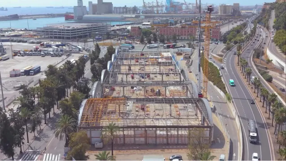 Aerial view of the Moll Adossat cruise terminals at the Port of Barcelona undergoing redevelopment, with construction zones marked and new infrastructure planned.